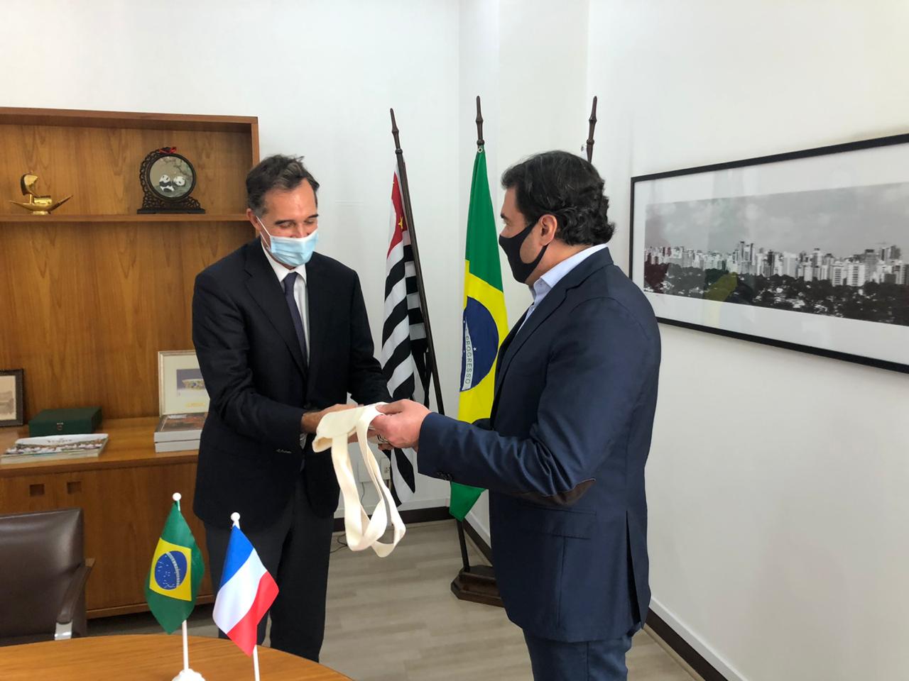 O Secretário de Relações Internacionais, Luiz Alvaro, e o Novo Cônsul da França conversam olhando um para o outro.